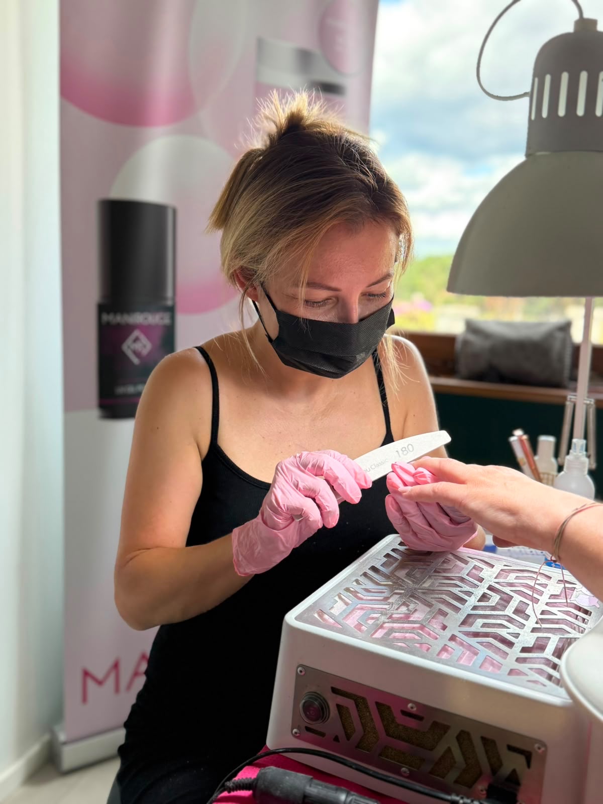 Kasia aan het werk aan haar tafel, ze vijlt de nagels van een klant